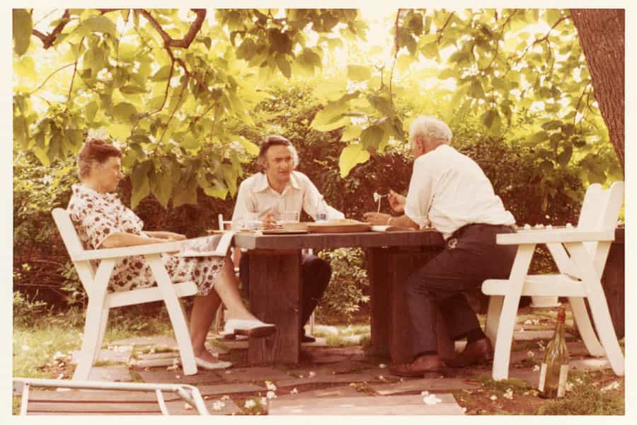 1970 - Tatyana Grosman, Larry Rivers, and Maurice Grosman eating outside of Skidmore Place under the Catalpa Tree.