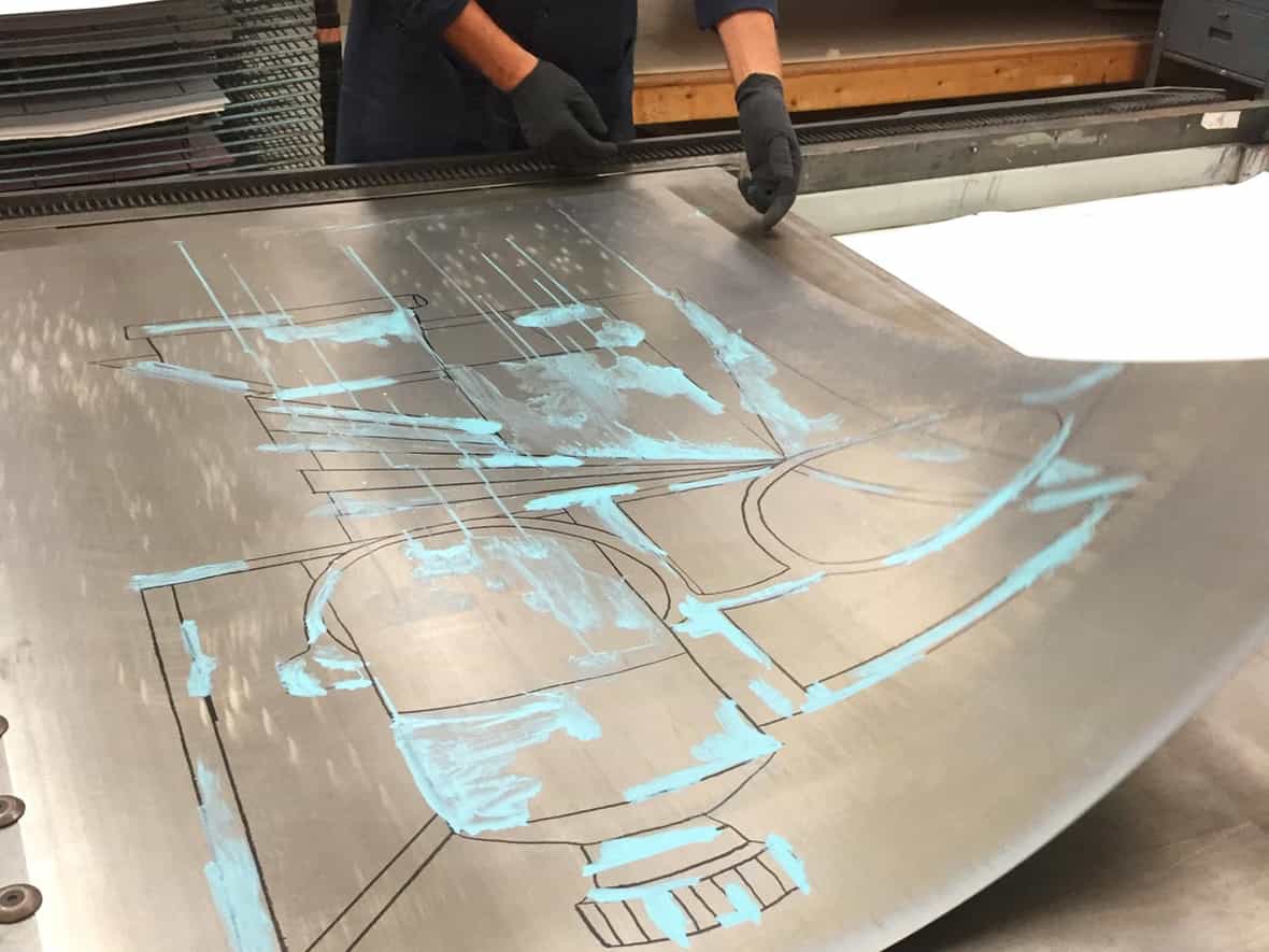 Printmaker Bruce Wankel removing a sheet of lead from a transfer lithographic press after printing a color.